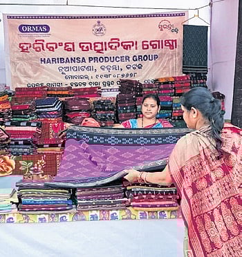 A visitor checks out a handloom saree at at a stall in Swadeshi Mela on Friday