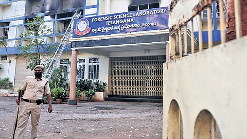 A cop stands guard near the TGFSL after fire accident.