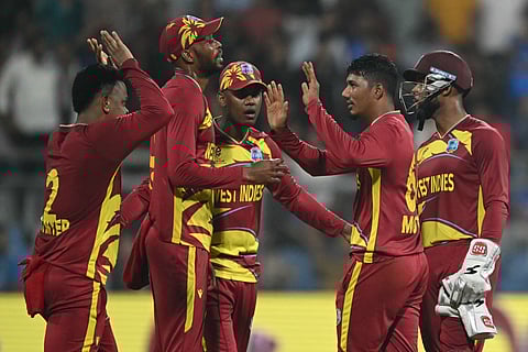 Gudakesh Motie (2nd from R) celebrates a wicket with his teammates on Wednesday 