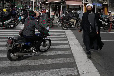 A cleric crosses an intersection in downtown Tehran, Iran, Monday, Feb. 9, 2026.