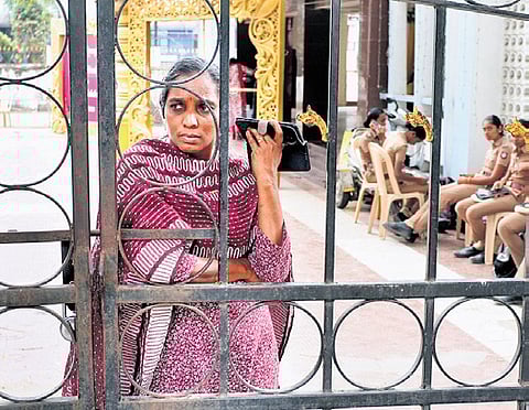 A detained employee talks over phone at a community marriage hall at Thirumangalam.