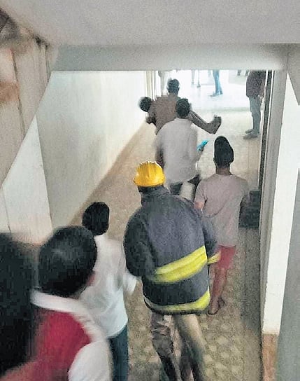 Firemen evacuating residents from the complex