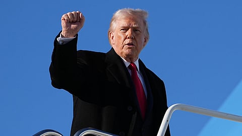 US President Donald Trump gestures as he boards Air Force One at Pope Army Airfield, in Fort Bragg, N.C., on February 13, 2026.