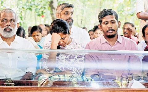 Parents of Aalin Sherin Abraham, who donated organs to five people after her death in an accident, sit beside her mortal remains 