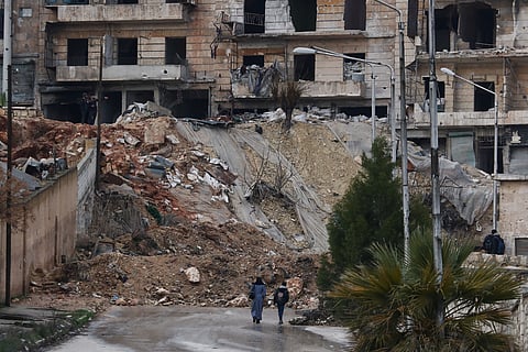 People walk along a street in the Kurdish-majority neighborhood of Sheikh Maqsoud, in Aleppo, Syria, Saturday, Feb. 14, 2026. 