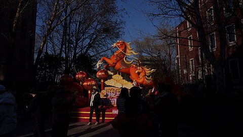 Visitors walk past illuminated festive decorations during the second day of Lunar New Year celebrations at a temple fair in Beijing on Wednesday, Feb. 18, 2026.