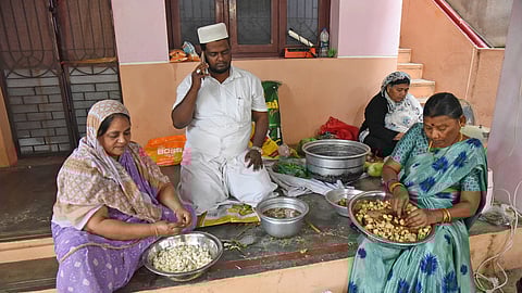 M Mydeen Abdul Khader with his family members and neighbor Rajeswari preparing Ramzon Sahar food to distribute college students for free in Tiruchy on Friday. 