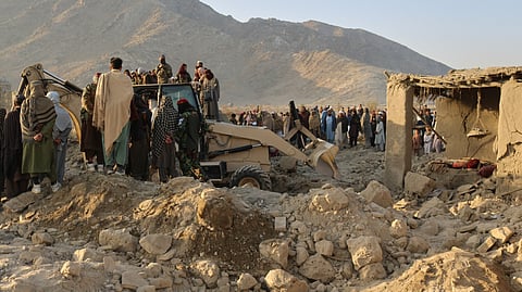 Local residents and civil defense workers look on as a bulldozer clears the rubble of a house hit by a cross-border Pakistani army strike in the Behsud district of Nangarhar province, Afghanistan, Sunday, Feb. 22, 2026.