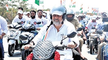 DCM DK Shivakumar rides a bike ahead of the Congress protest against VB-G RAM G at Chikkaballapur on Monday
