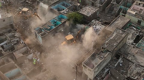 An aerial view of a demolition drive underway to clear illegal houses along the Aji river banks and TP Road in the Jangleshwar area, in Rajkot, Gujarat, Monday, Feb. 23, 2026.