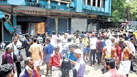 People near the building where a heavy slab collapsed, killing four headload workers, at Valiyangadi in Kozhikode on Monday 