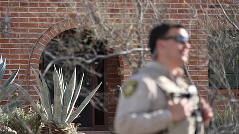 A member of the Pima County Sheriff's Department stands in front of the front door of the house of Nancy Guthrie, the missing mother of “Today” show host Savannah Guthrie, Tuesday, Feb. 10, 2026, in Tucson, Ariz. 