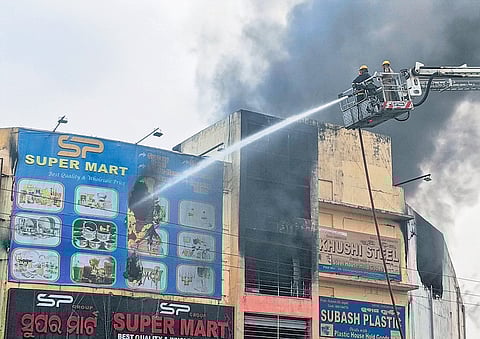 Firefighters dousing the blaze at SP Super Mart in Lingipur on Tuesday  