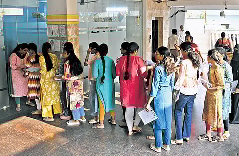 On the first day of the Intermediate Public Examinations in Telangana, first-year students wait in a queue and check their details 