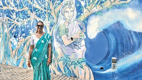 Artist Dey MKO with her mural at Manaveeyam Veedhi    