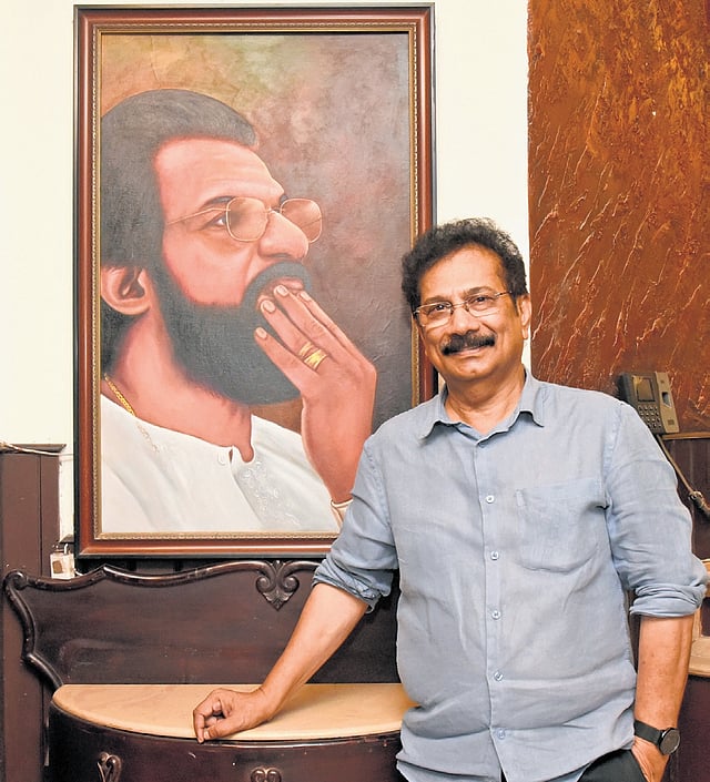 C A Nazer, who now owns the house, standing next to a portrait of Yesudas