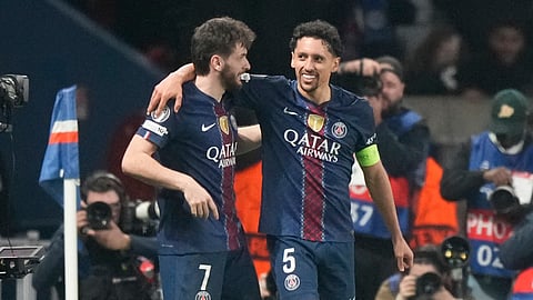 PSG's Khvicha Kvaratskhelia.left, and Marquinhos hug after a goal during a Champions League second leg playoff soccer match between Paris Saint-Germain and Monaco in Paris Wednesday, Feb. 25, 2026. 
