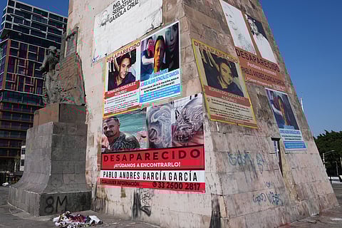 Posters bearing the faces of missing people cover the Ninos Heroes monument in Guadalajara, Mexico, Wednesday, Feb. 25, 2026. 