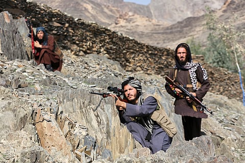 Afghan Taliban soldiers look toward the Pakistani side, with one peering through the sight of his rifle, on the Afghan side of the Torkham border crossing with Pakistan in Torkham, Afghanistan, Friday, Feb. 27, 2026. 