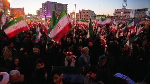 Government supporters wave Iranian flags in a mourning ceremony after state TV officially announced the death of Iranian Supreme Leader Ayatollah Ali Khamenei, in Tehran, Iran, Sunday, March 1, 2026.