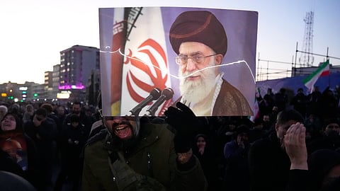 Government supporters mourn in a gathering after state TV officially announced the death of Iranian Supreme Leader Ayatollah Ali Khamenei, shown in the poster, in Tehran, Iran, Sunday, March 1, 2026.
