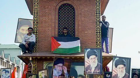 Srinagar: Protesters hold portraits of Iran's Supreme Leader Ali Khamenei and and Palestinian flags during a protest against the alleged killing of Khamenei in US-Israel strikes, at Ghanta Ghar, in Srinagar, Sunday, Mar. 1, 2026.