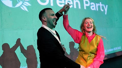 Green Party candidate Hannah Spencer, right, celebrates with party leader Zack Polanski at a volunteer event after winning the Gorton and Denton by-election, Manchester, England, February 27
