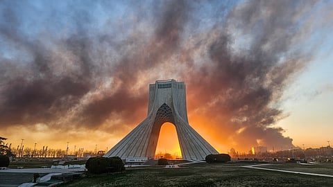 Smoke rises up behind Azadi, or Freedom Tower, following a US-Israeli military strike in Tehran, Iran, Tuesday, March 3, 2026.