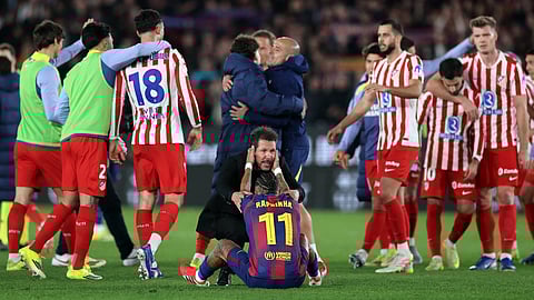 Atletico Madrid coach Diego Simeone (C) conforts Barcelona's Brazilian forward Raphinha at the end of the Copa del Rey (King's Cup) semi final second leg football match between FC Barcelona and Club Atletico de Madrid on March 3, 2026. 