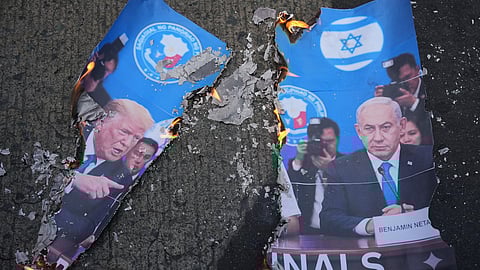A picture of US President Donald Trump, left, and Israeli Prime Minister Benjamin Netanyahu burns as protesters hold a rally to condemn the Iran war near the US Embassy in Manila, Philippines, on Friday, March 6, 2026.