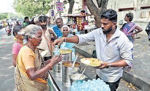 Arun serving a free mid-day meal to an elderly woman in Puducherry, part of his effort to feed the needy.