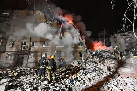 Firefighters extinguish a blaze and clear rubble at a five-story residential building in Kharkiv on March 7, 2026, after it was partially destroyed by a Russian strike amid the Russian invasion of Ukraine.