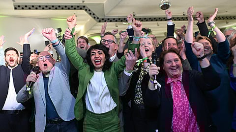 Members of the Greens including Muhterem Aras (C), president of the parliament in Baden-Wuerttemberg, Winfried Hermann (2nd L) Transport Minister and Green party parliamentary group leader Andreas Schwarz (behind) react after exit polls were announced in the state elections on March 8, 2026 in Stuttgart, southern Germany.