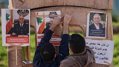 Family members of retired Lebanese officer Ahmed Shukr, hang posters of him during a gathering outside the headquarters of the U.N. Economic and Social Commission for Western Asia, ESCWA, in Beirut, Lebanon, Friday, Feb. 13, 2026.