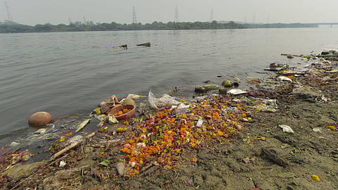 Waste material at Yamuna river bank after the end of Navaratri, at ITO in New Delhi on Saturday.