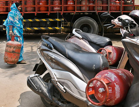 A woman carries an LPG cylinder as concerns grow over a looming shortage of cooking gas cylinders in Hyderabad. 