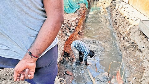 A worker clearing the sewage-mixed stormwater drain at Arumbakkam on Tuesday.