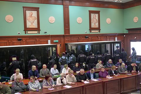 Men tried on the charges of involvement in a terror attack at the Crocus City Hall in March 2024 listen to the verdict in a glass cage at the Second Western District Military Court in Moscow, Russia, Thursday, March 12, 2026. 