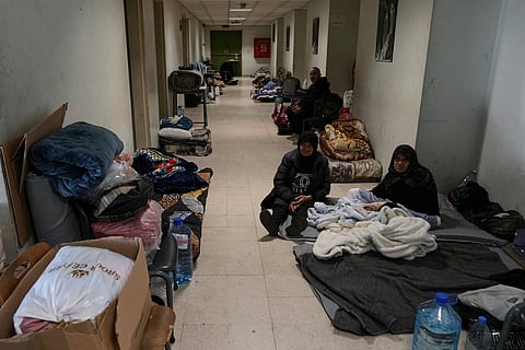 Displaced people fleeing Israeli airstrikes in southern Lebanon and Dahiyeh, Beirut's southern suburbs, settle at the Bir Hassan Technical Institute, which has been turned into a shelter, in Beirut, Lebanon, Wednesday, March 11, 2026.