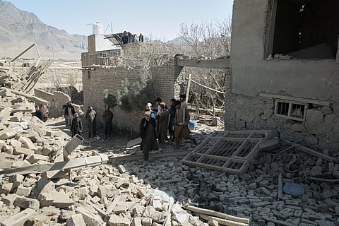 Residents inspect the site of a strike in Kabul, Afghanistan, Friday, March 13, 2026.