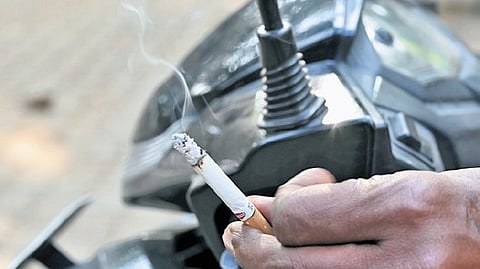 A motorist smoking a cigarette at a traffic signal in Bengaluru.