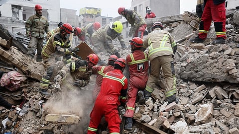 Rescue workers search for survivors in the rubble after a strike in southern Tehran, Iran, Friday, March 13, 2026.