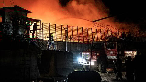 Afghan firefighters and Taliban security personnel work to extinguish a fire at the Secondary Rehabilitation Services Centre in Kabul on March 16, 2026.