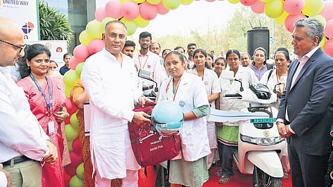 Health Minister Dinesh Gundu Rao hands over an e-bike to an ASHA worker during a programme at Arogya Soudha on Tuesday.
