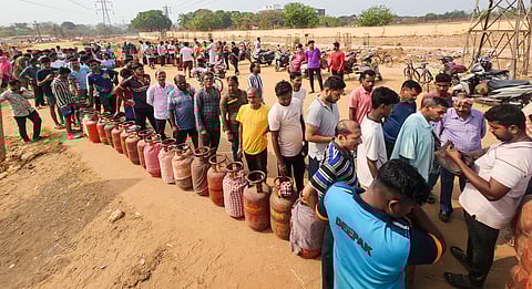 People queue up with their empty cylinders outside an LPG depot to receive refilled ones, amid supply crisis in the country, in Bhubaneswar, Odisha, Friday, March 13, 2026.