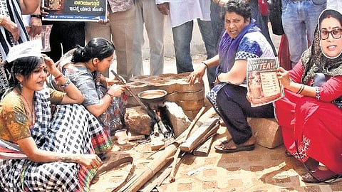 Members of Aam Aadmi Party (AAP) use firewood to make Tea as they protest against the central government alleging it has not properly maintained LPG gas issue, at Freedom Park in Bengaluru on Tuesday.