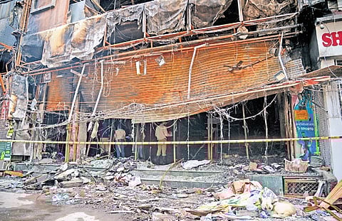 Forensic and police teams collect evidence from the site of the fire.