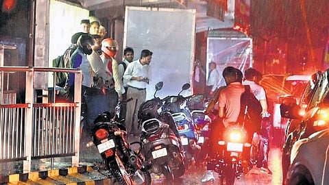 People take shelter as rain lashes parts of the capital on Wednesday.