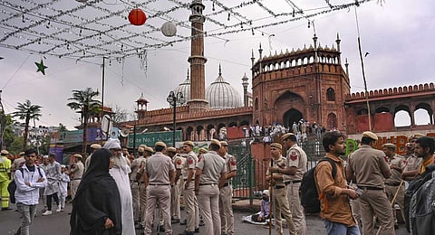 Police personnel stand guard as people arrive to offer prayers at Jama Masjid ahead of the Eid Al-Fitr festival celebrations, in New Delhi, Friday, March 20, 2026. 