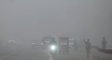 Vehicles moves in slow speed amid low visibility due to dense fog in New Delhi on Saturday.